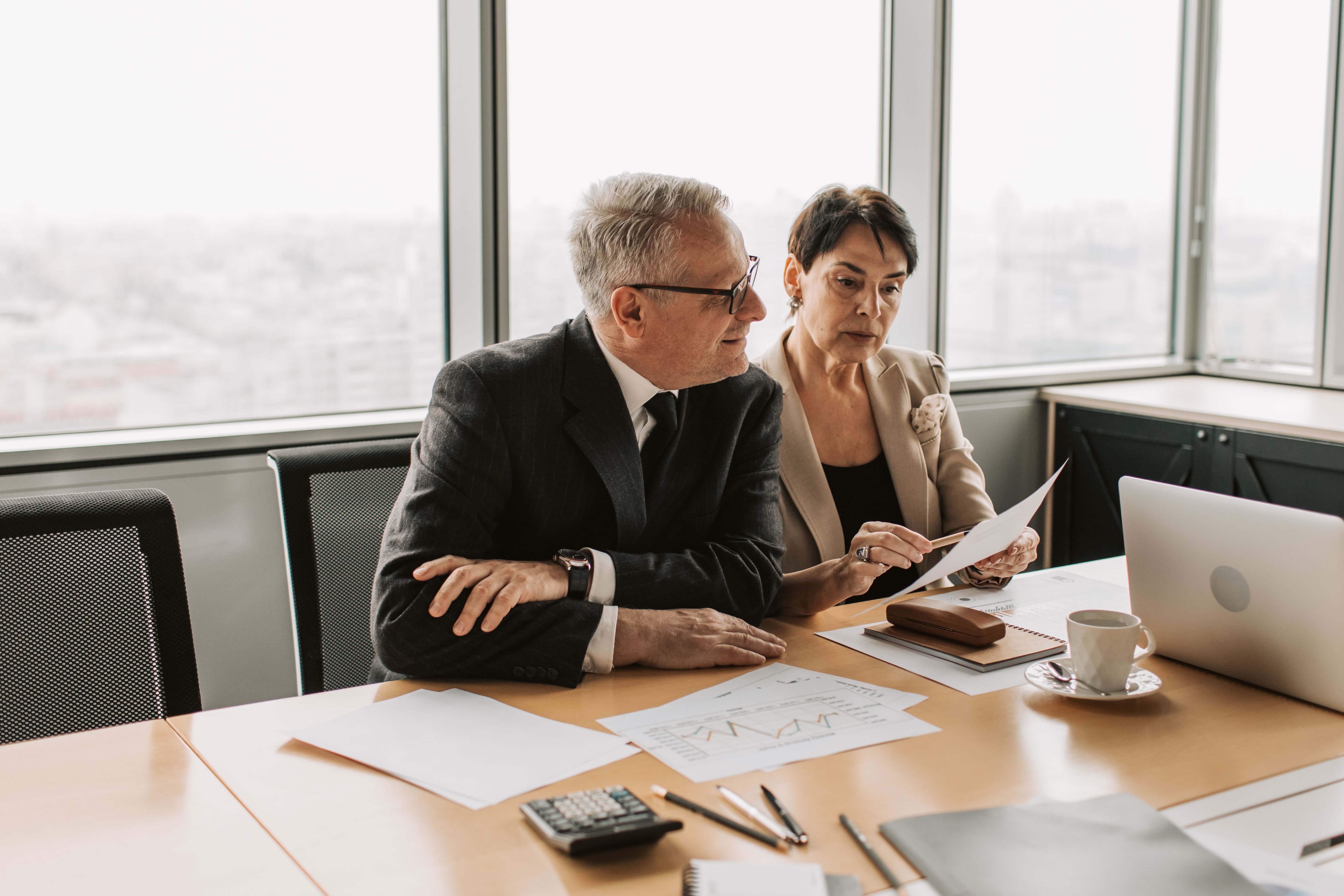 Dois advisors analisando documentos em uma reunião de assessoria de investimentos